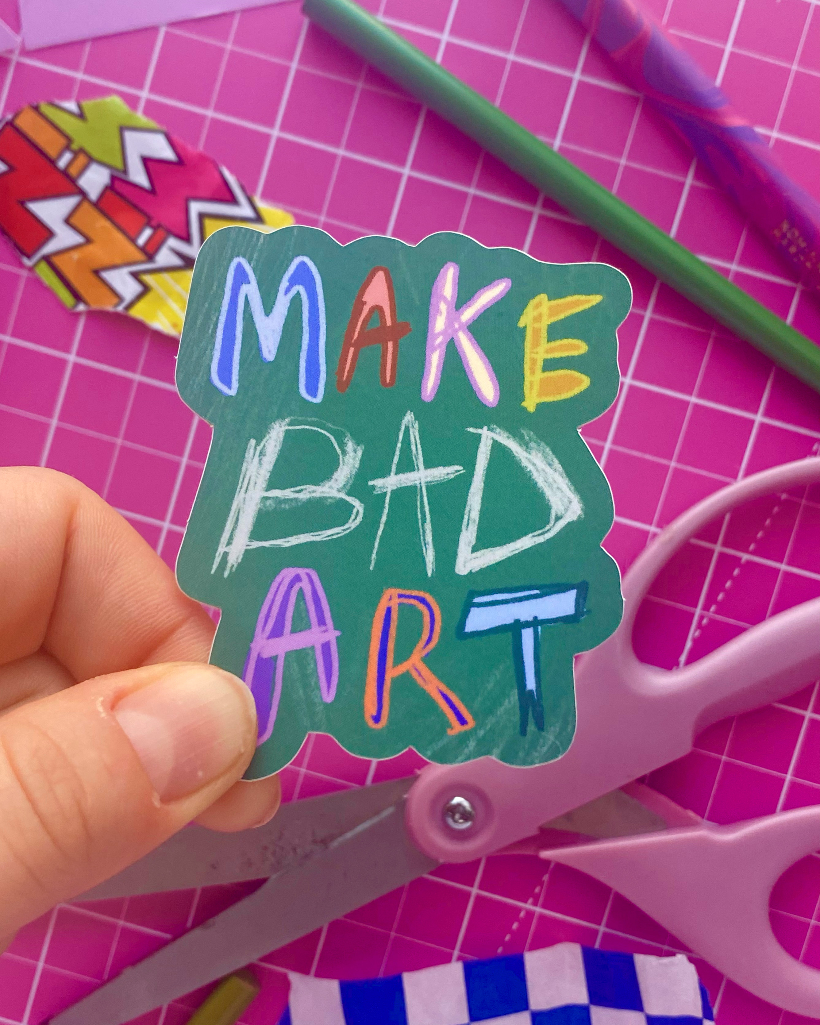 Sticker with colourful, scratchy writing telling you to MAKE SHITTY ART!!